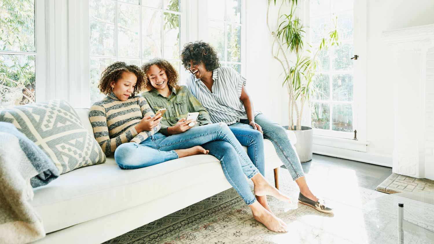 Mother and daughters sitting on couch