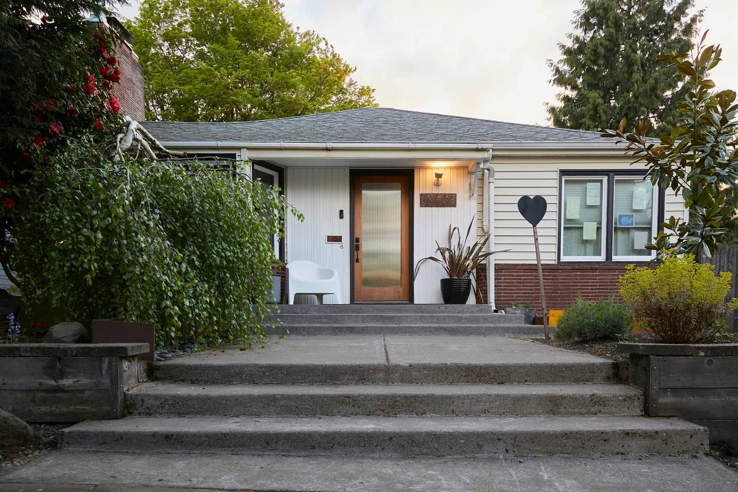 A front wooden door of a house with a porch