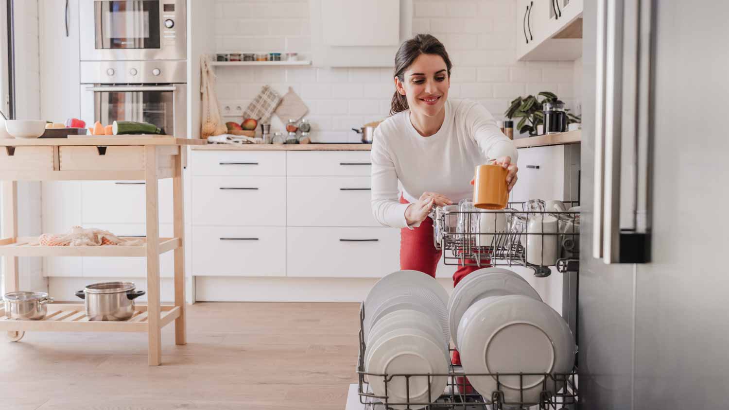 Woman arranging crockery in dishwasher
