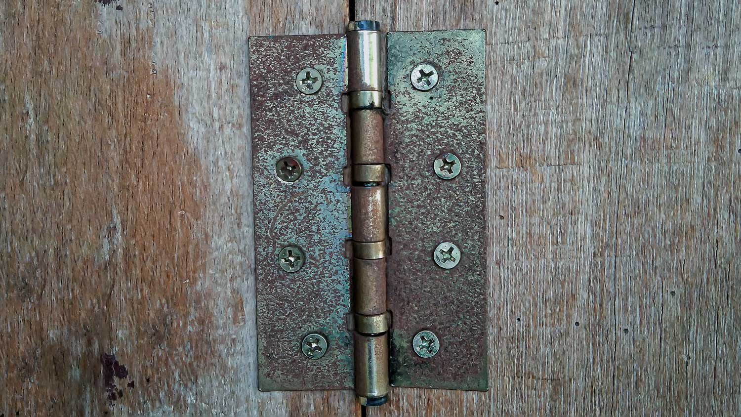 Rusty brown door hinge on the board