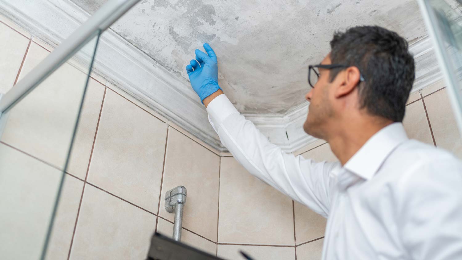 A contractor inspecting mold on ceiling