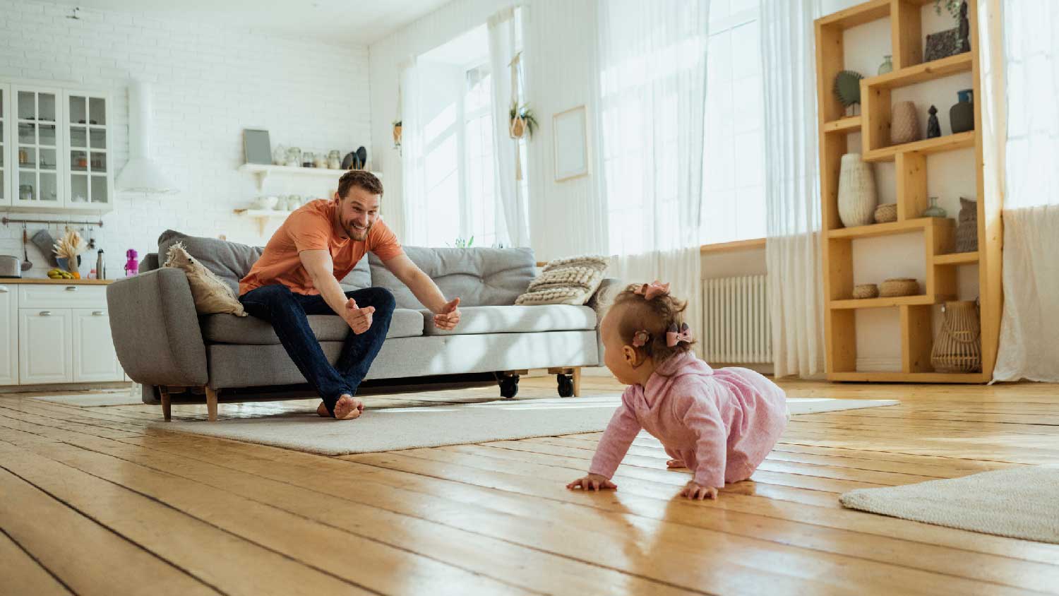 A father playing with her daughter crawling on the floor