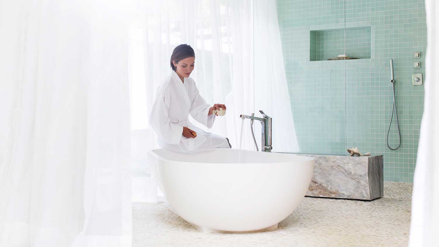 Woman filling freestanding bathtub with water