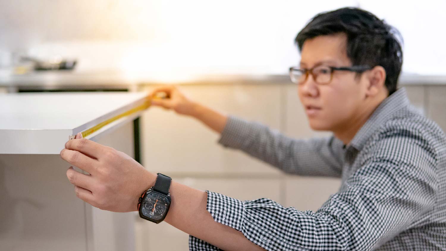 A man measuring a laminate countertop