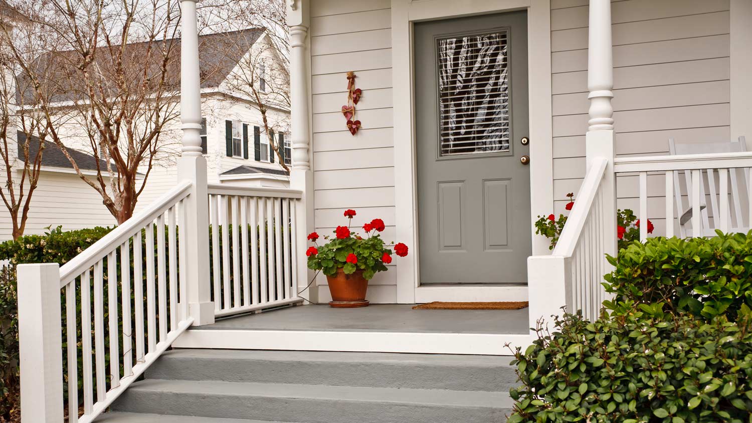 A traditional front porch with a wooden door and glass window