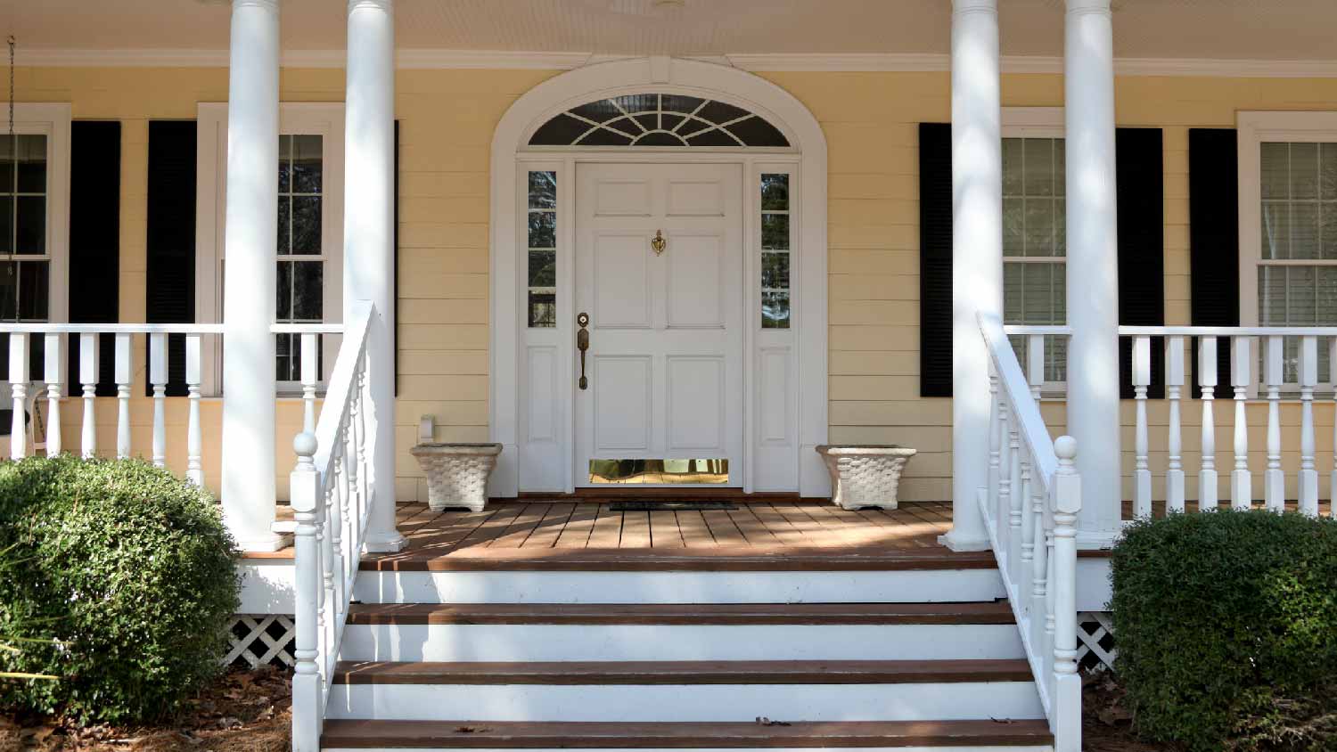 A front porch with a kick plate on the door