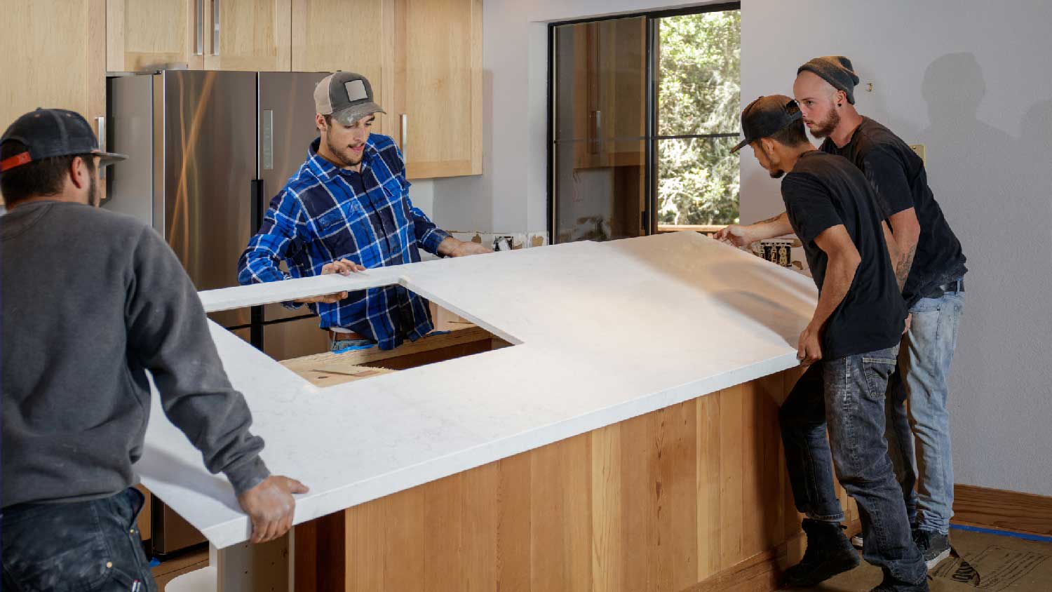 A group of workers installing a quartz countertop
