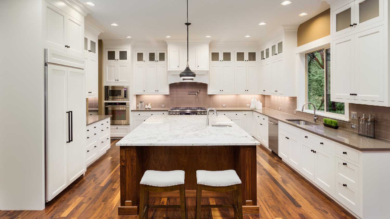 A spacious kitchen with different colored granite countertop on the kitchen island