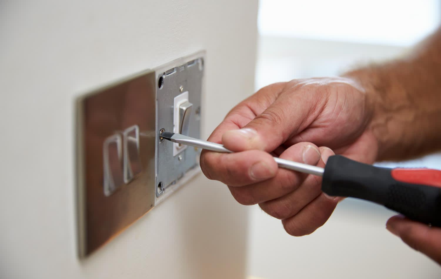 Close up of electrician checking a domestic light switch