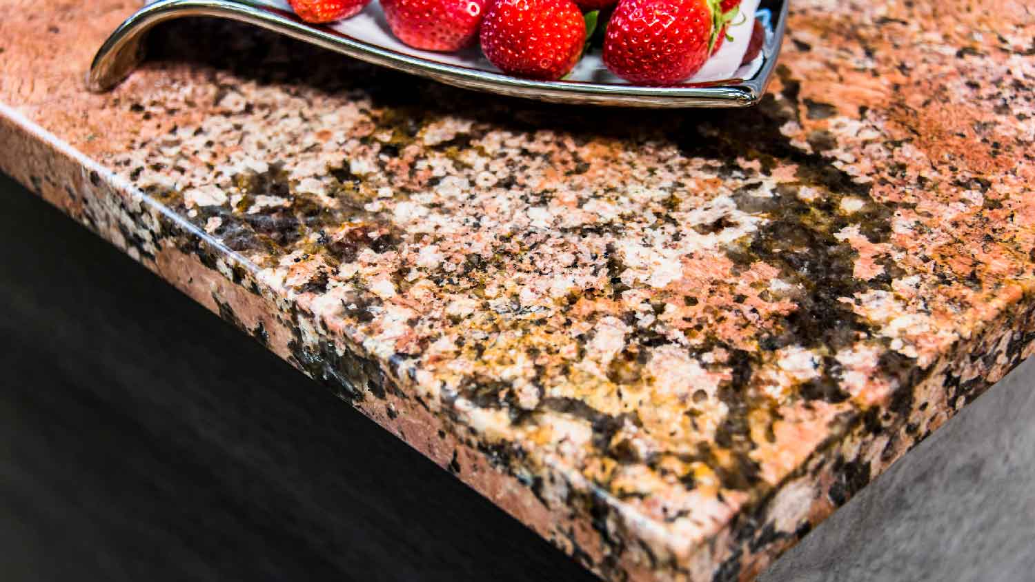 A pink granite countertop with strawberries on it