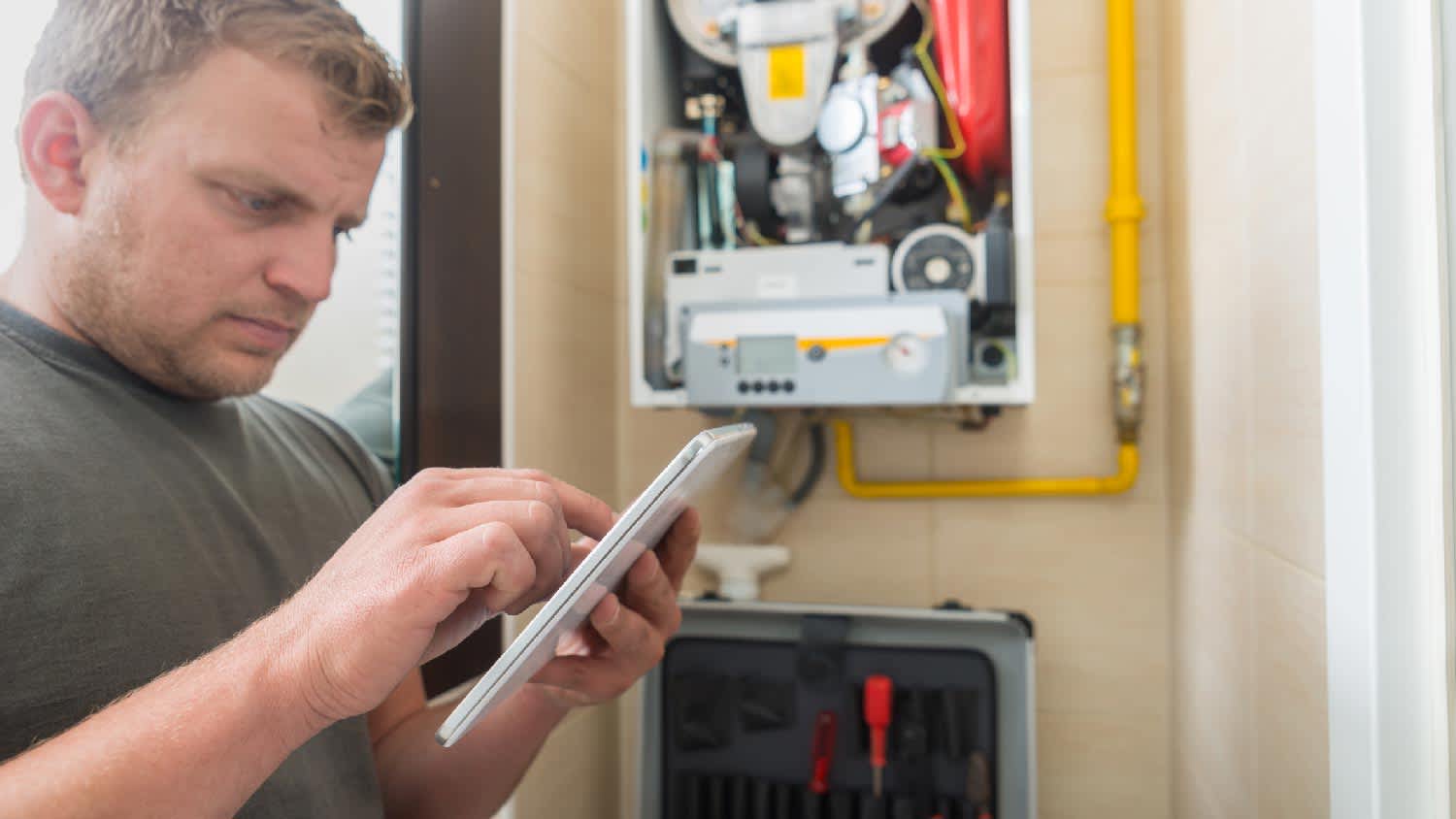 A technician inspecting a domestic furnace