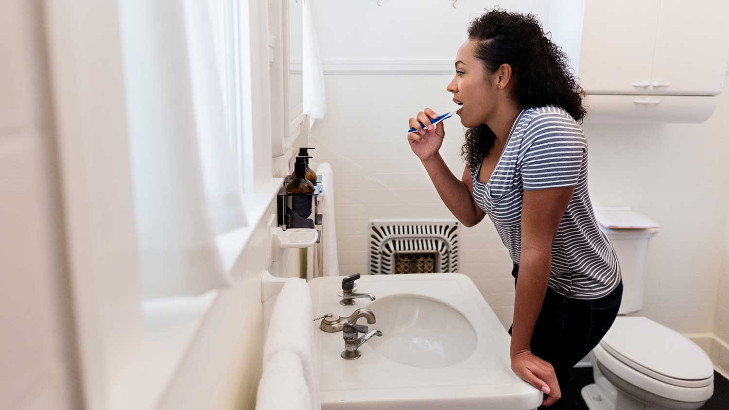 Woman brushing teeth in the bathroom
