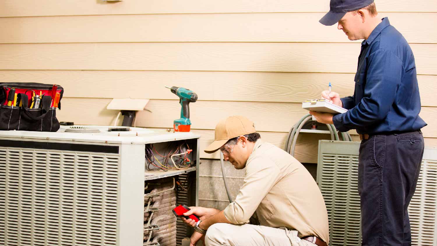 Two professionals installing new AC unit