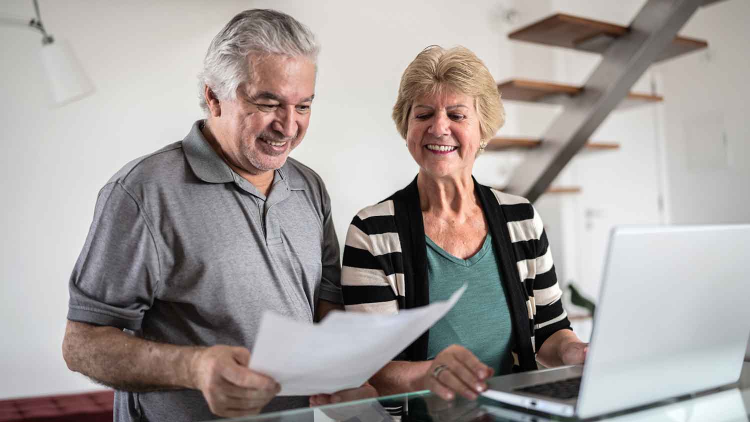 Happy senior couple working on home finances