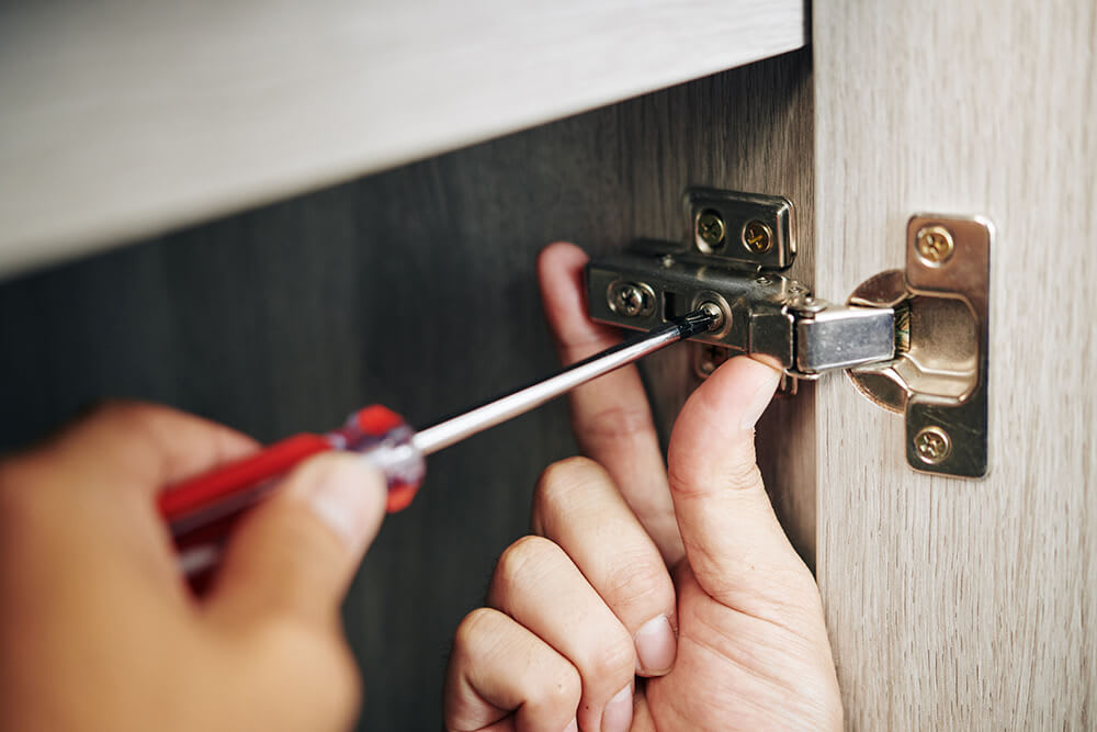 Person installing a cabinet hinge
