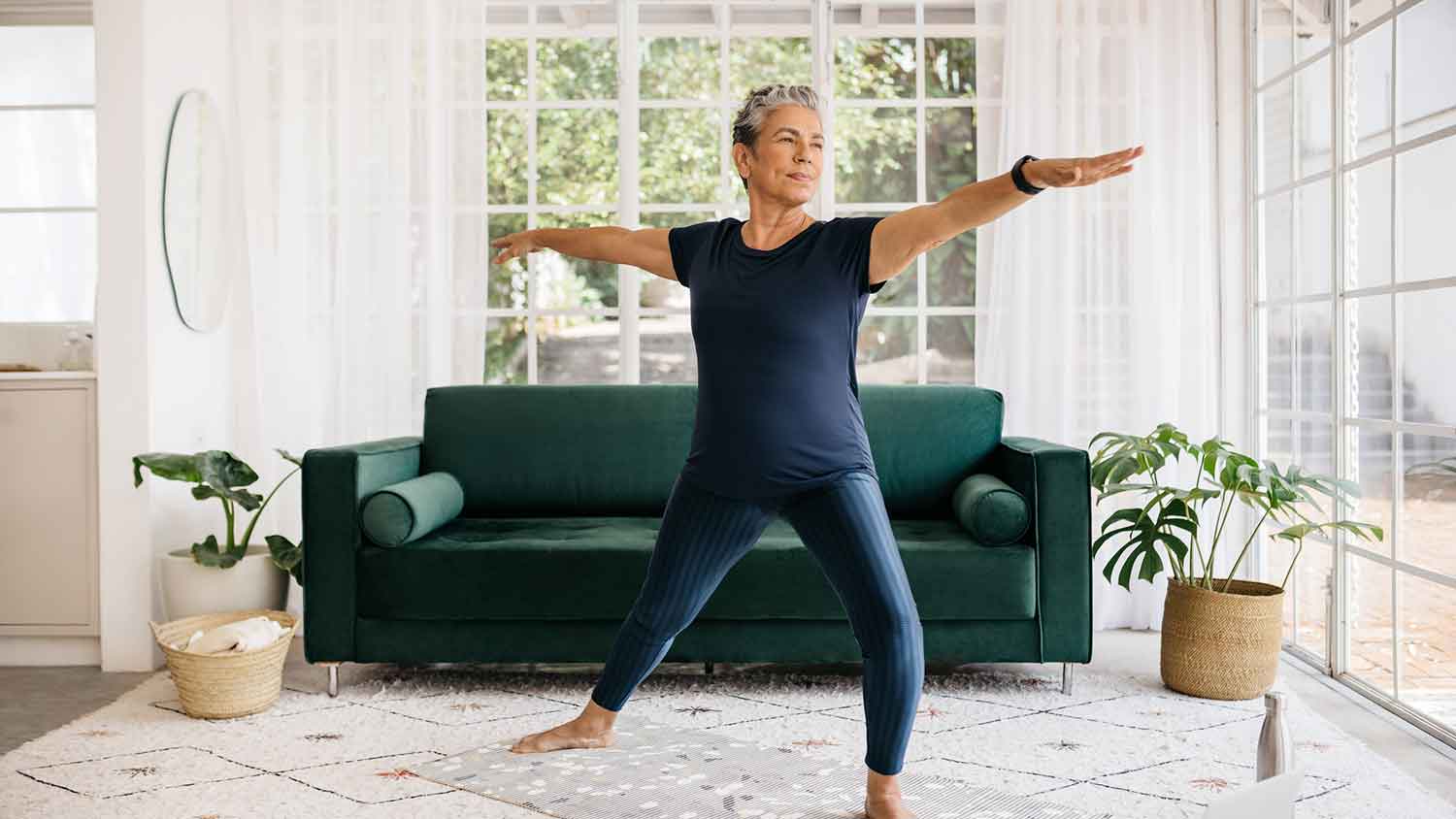 Mature woman doing yoga in her living room