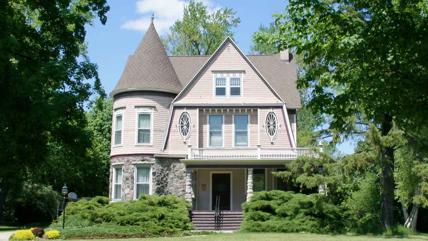Victorian style home exterior surrounded by trees