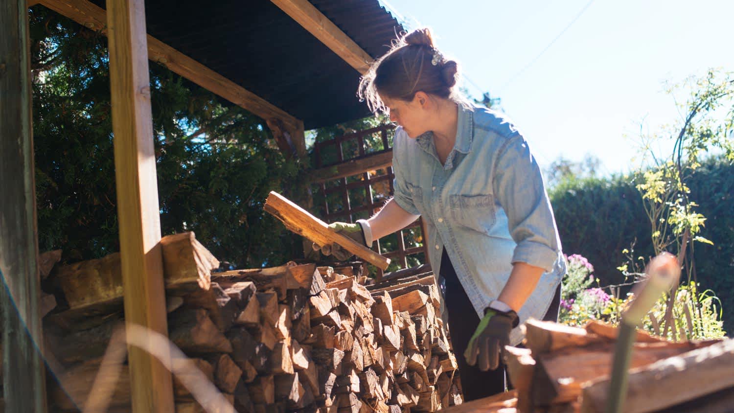A woman stashing firewood for the upcoming winter