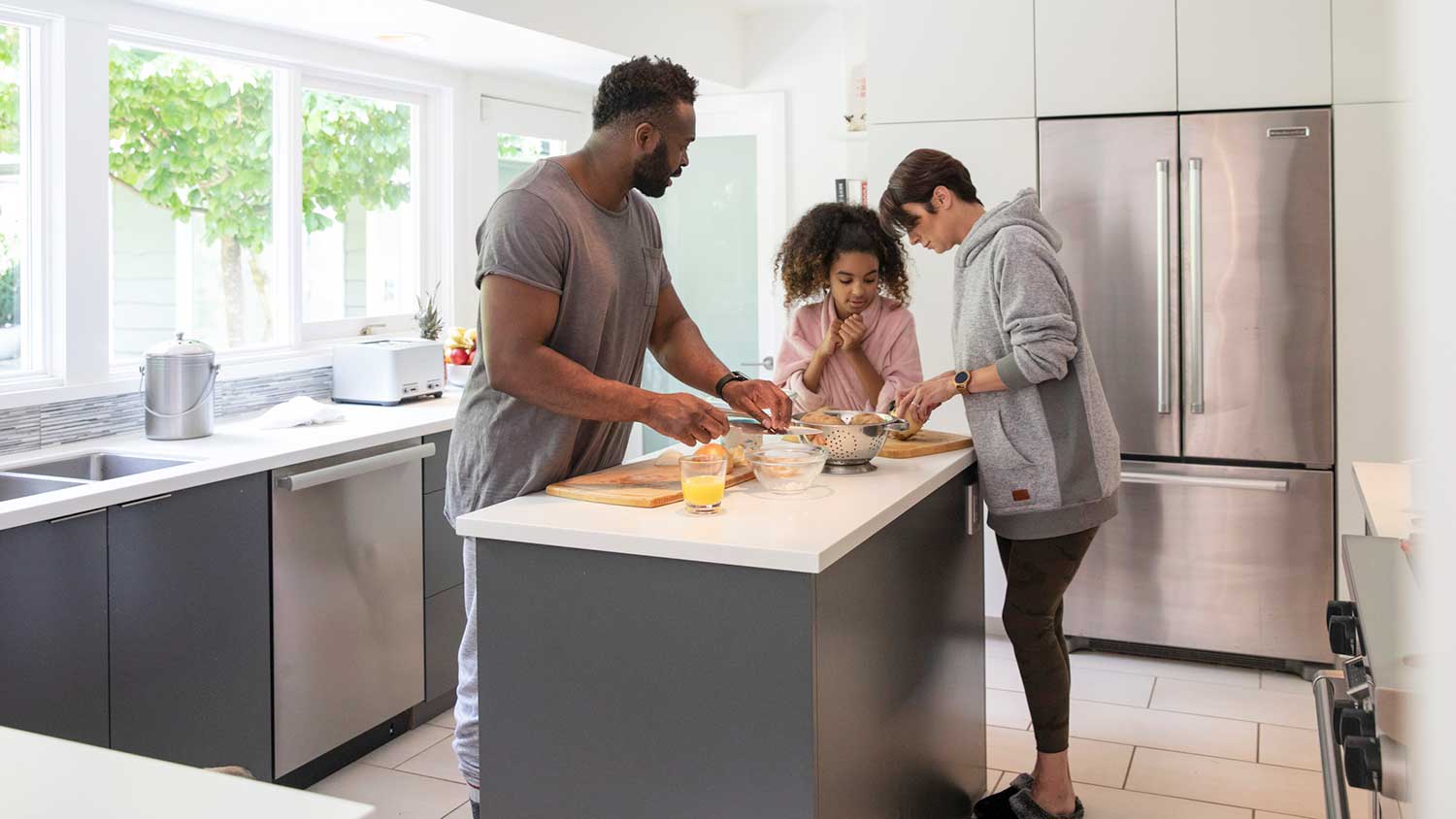 Daughter helping parents make breakfast at home