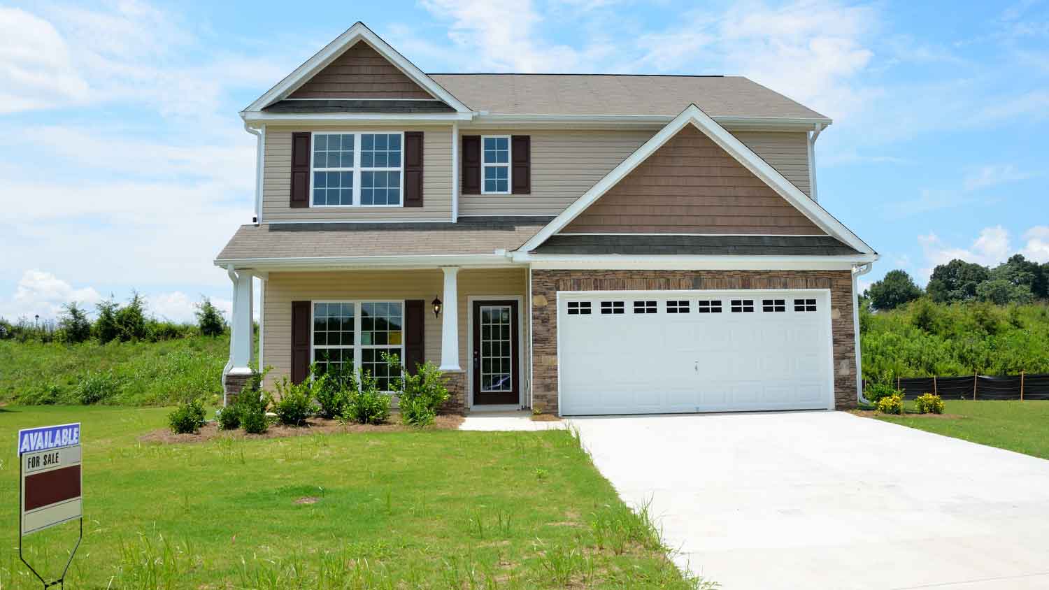 Home exterior with for sale sign in the yard
