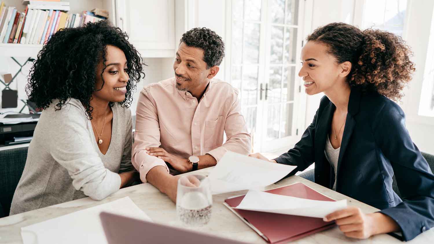 Couple and real estate agent reviewing paperwork