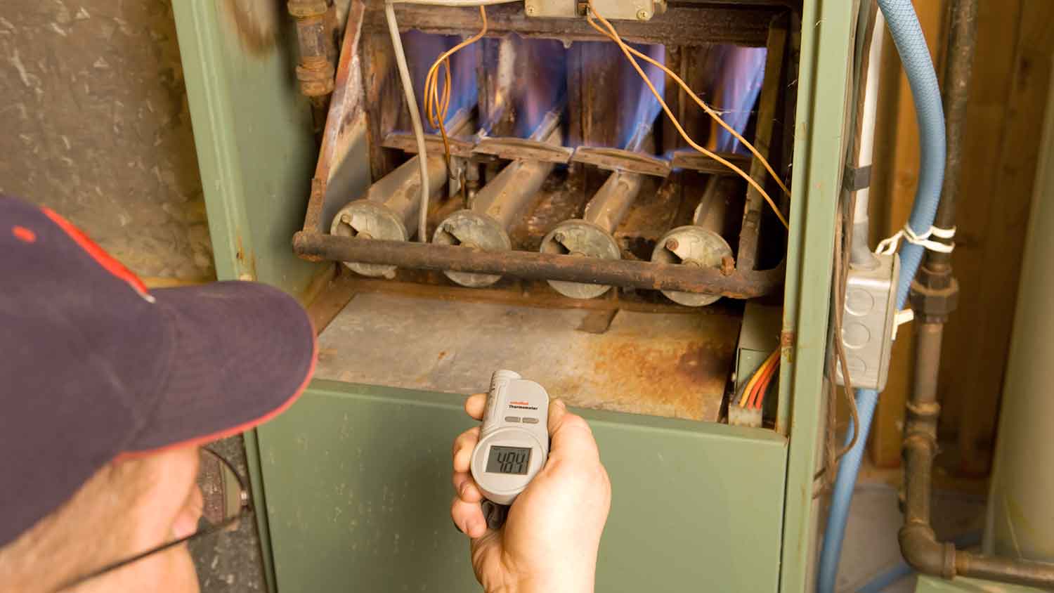 HVAC professional repairing gas furnace burners