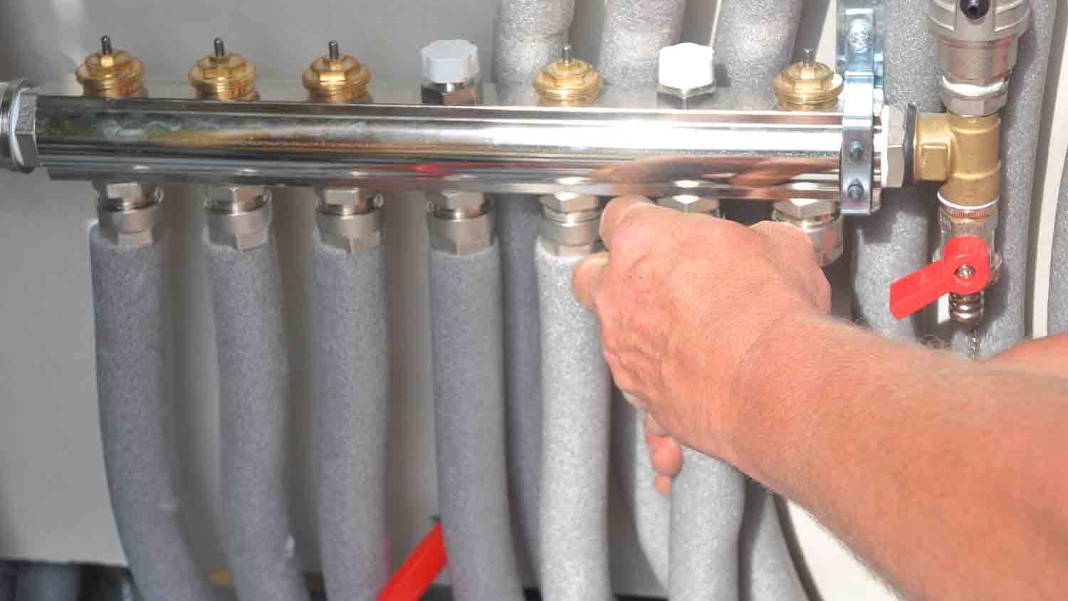 man installing insulation for pipes