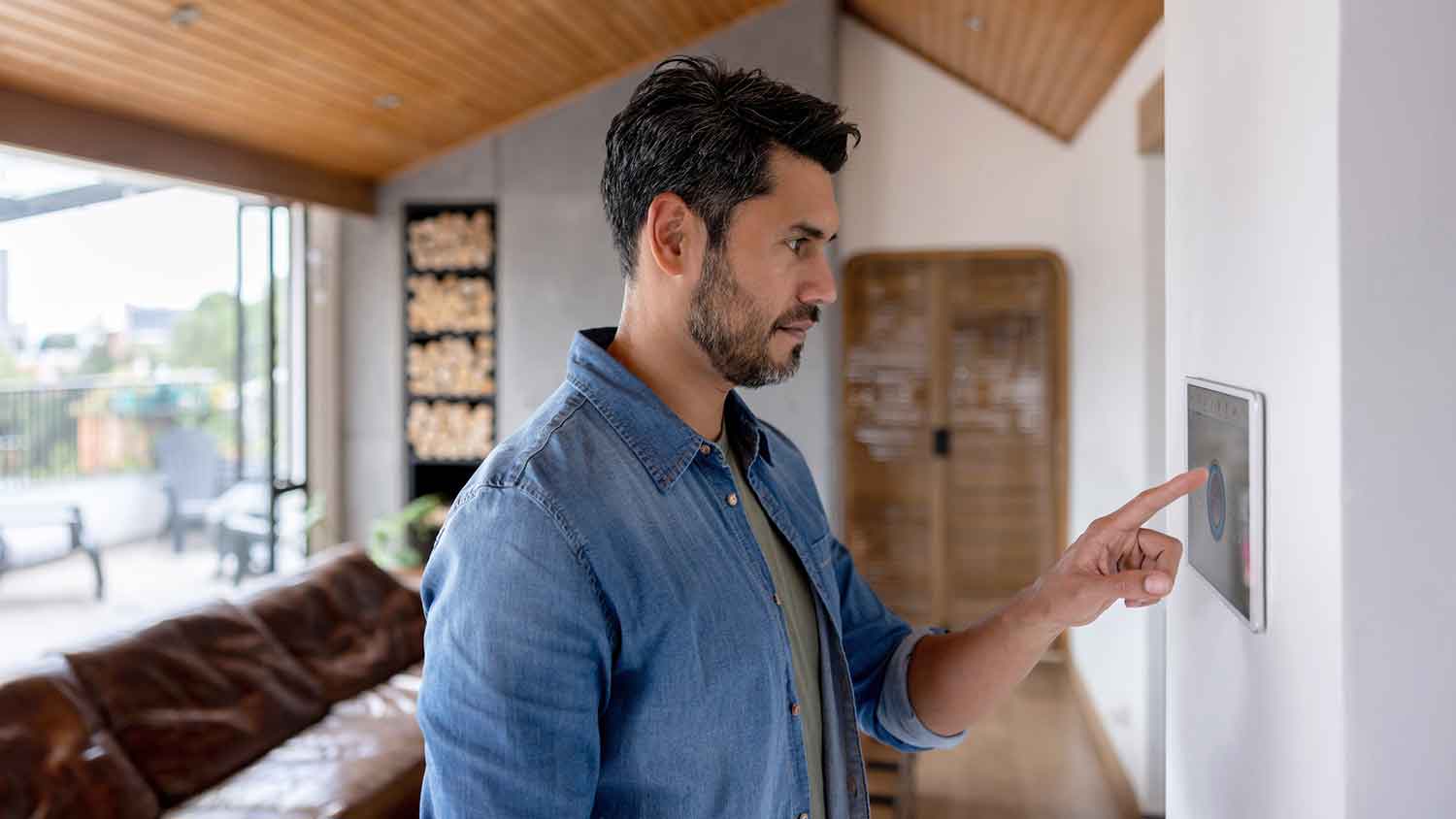 Man in the living room adjusting house thermostat