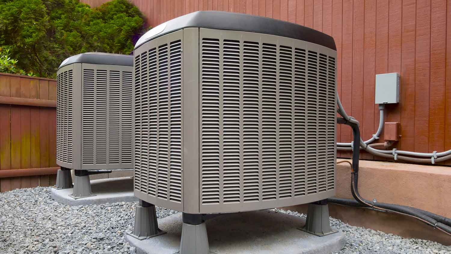 Air conditioner units on concrete slab outside the house
