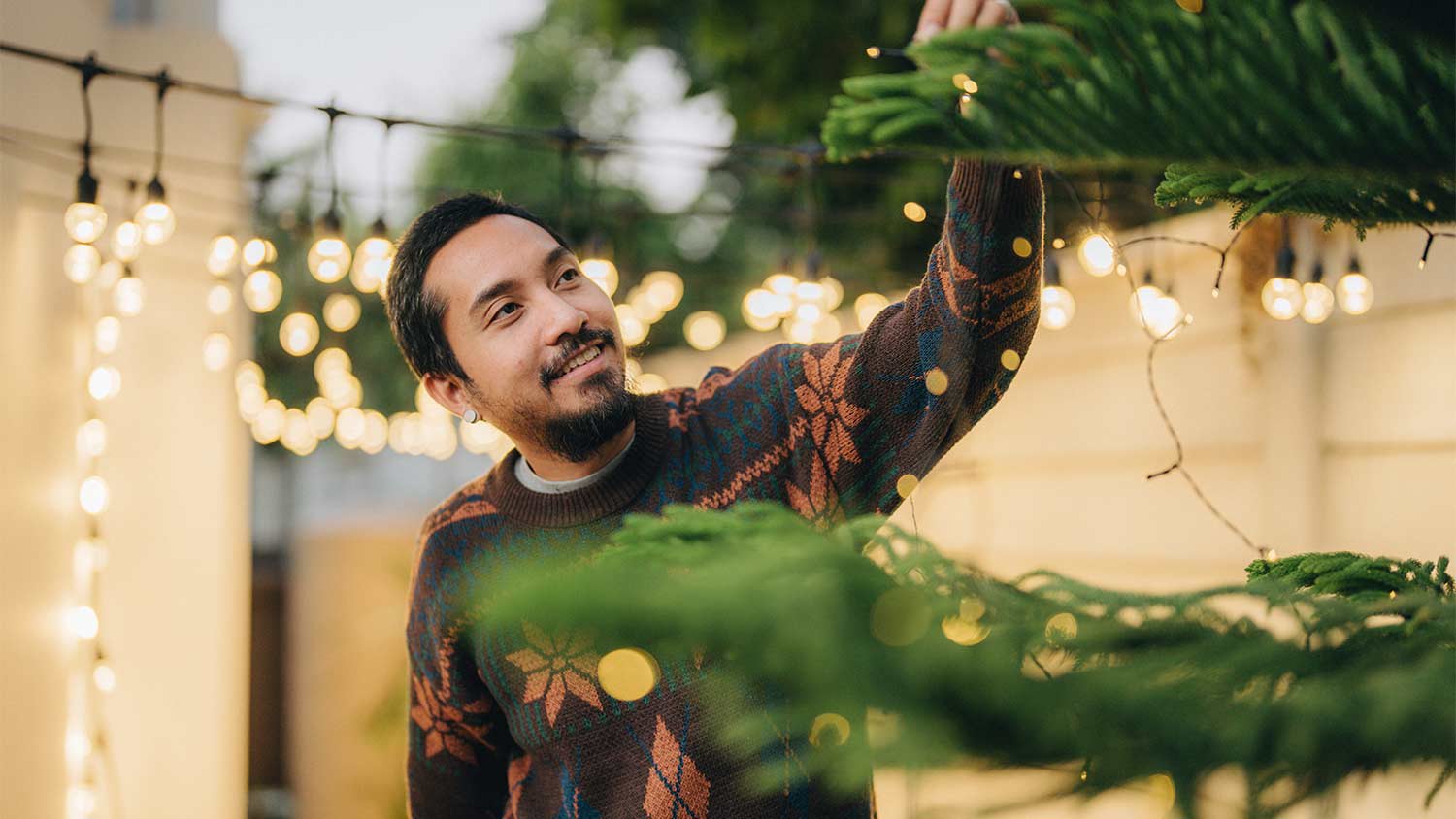 man decorating tree outside
