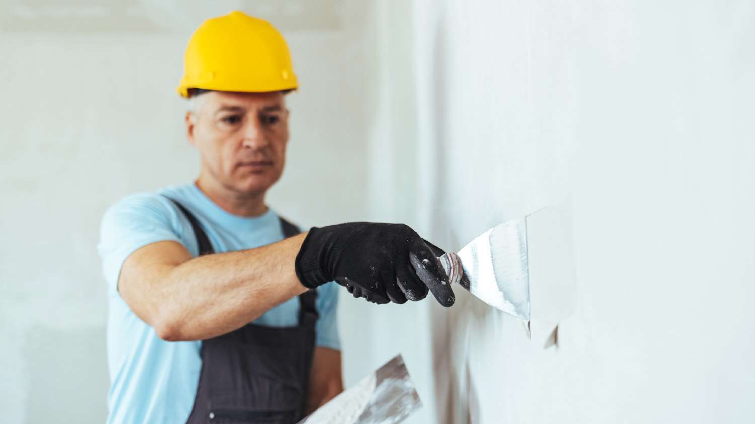 A man finishing a drywall