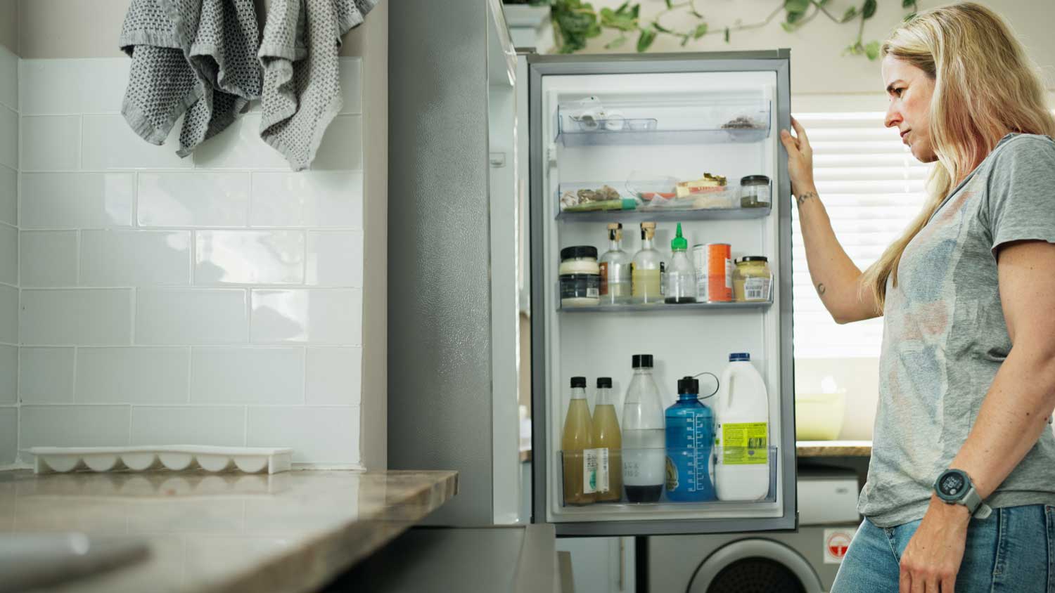 A woman looking inside her fridge