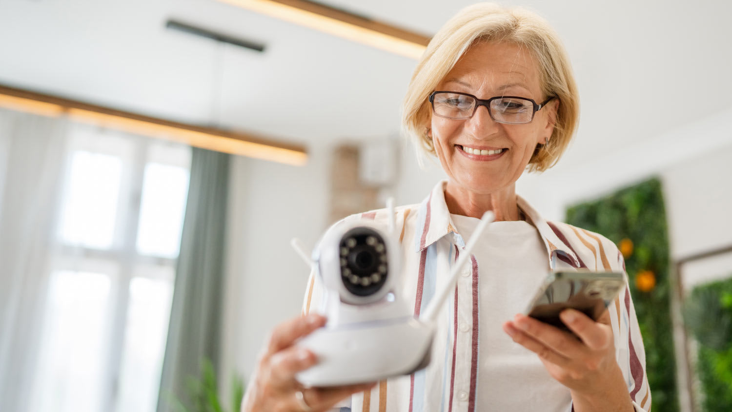 woman holding home security camera