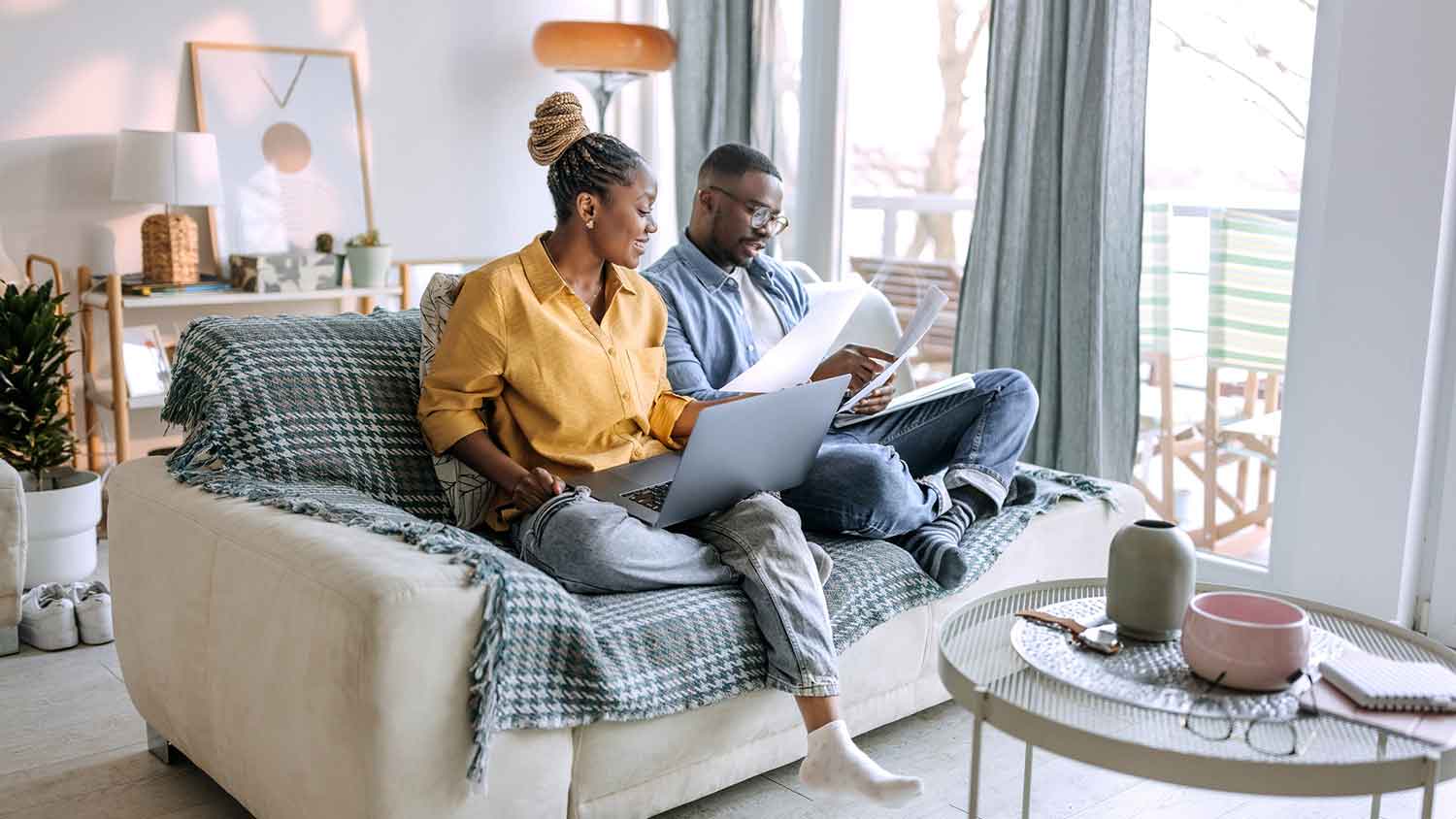 Couple sitting on the couch going over paperwork
