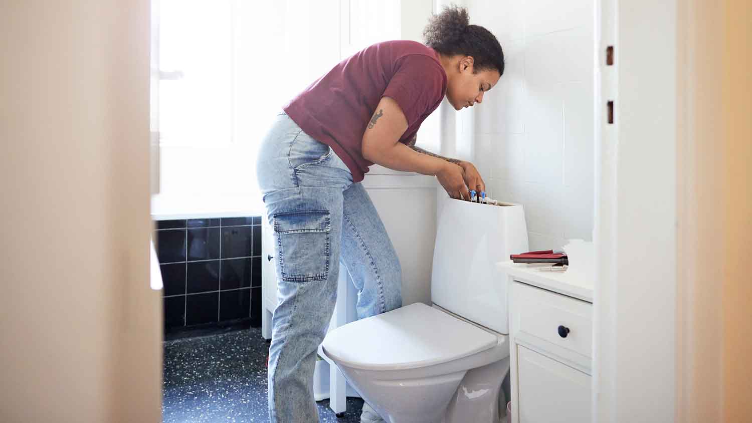 Woman fixing toilet fill valve