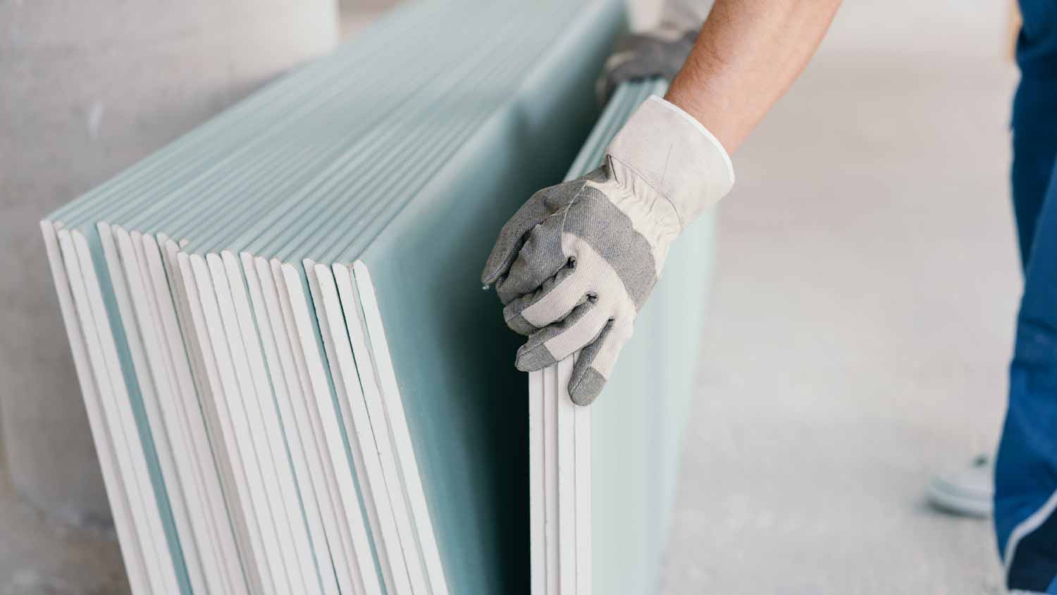 worker taking a sheet of chipboard