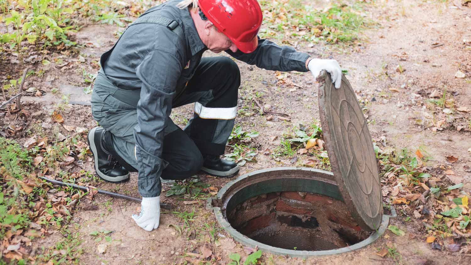 Worker cleaning drains