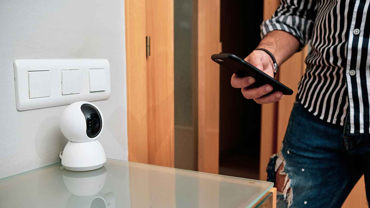 Man using smartphone to set up wireless camera