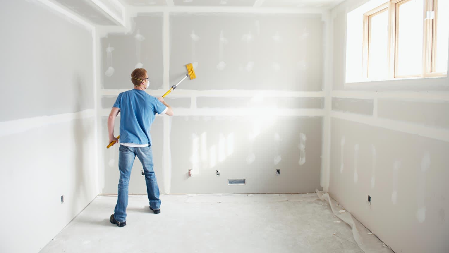 A man working on drywall