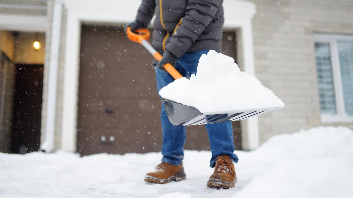 man shoveling snow in blizzard