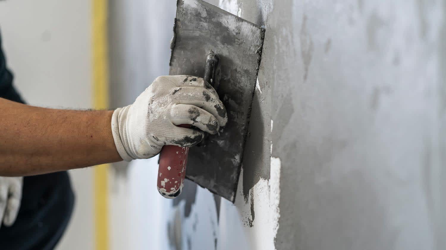 Close-up of a man applying cement plaster