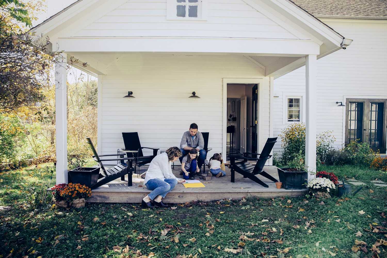 A family spending time at front porch of their rural home