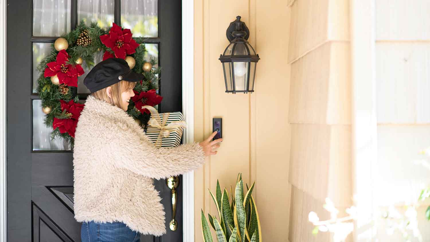 Woman holding Christmas present rings smart doorbell