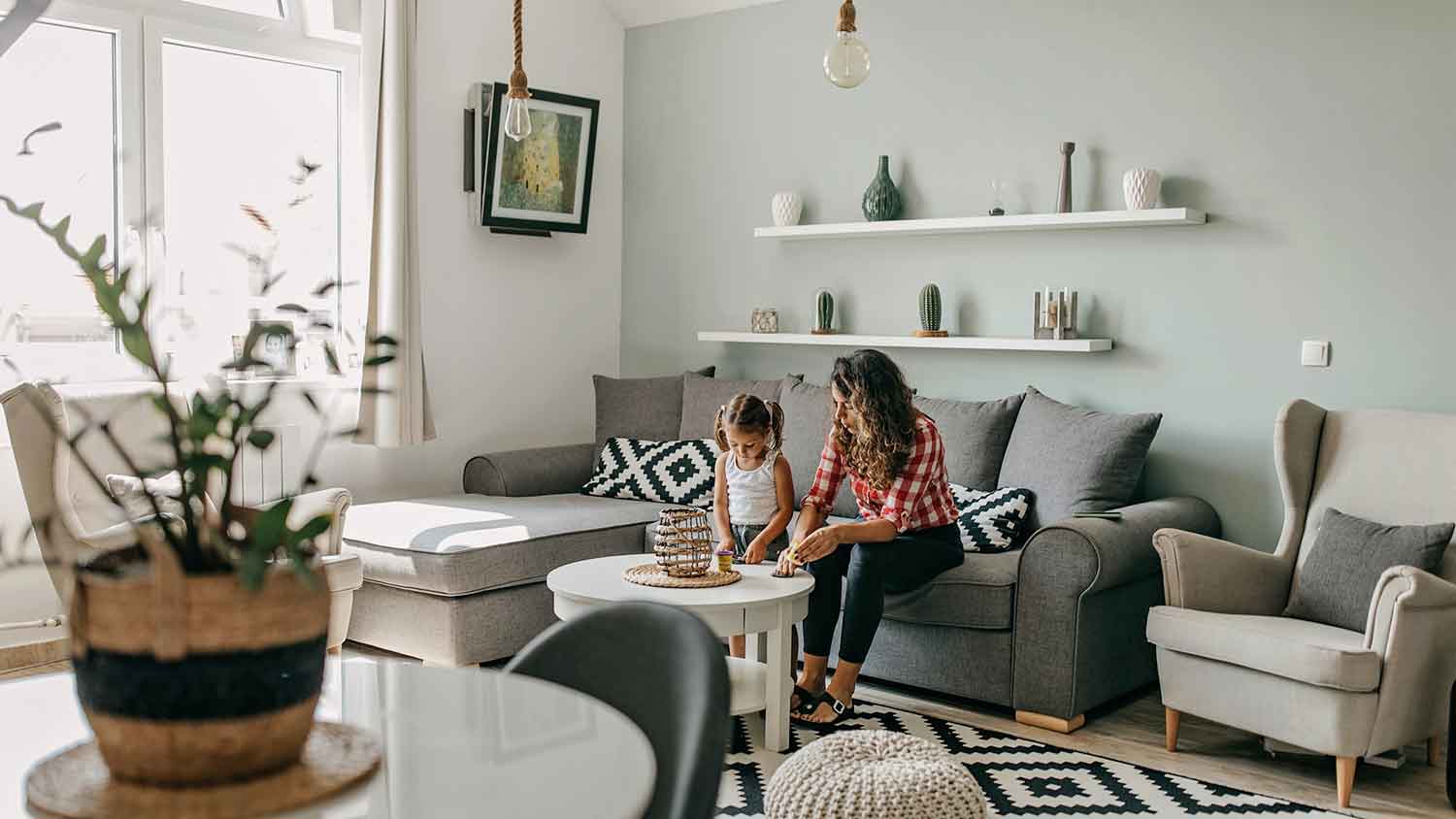 Mother and little daughter playing in the living room