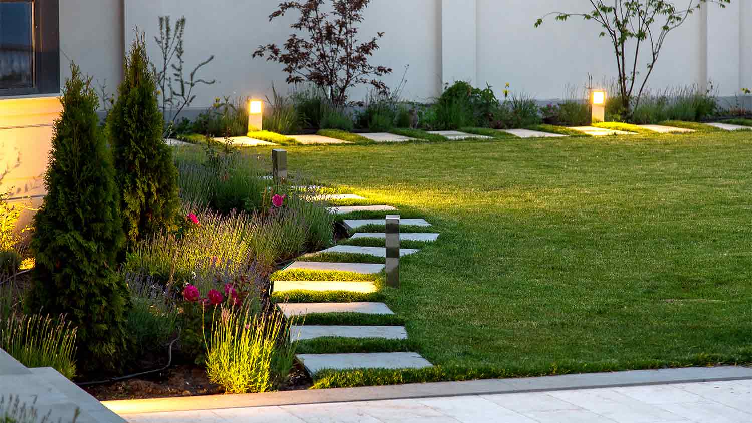 A view of a garden path with outdoor lighting