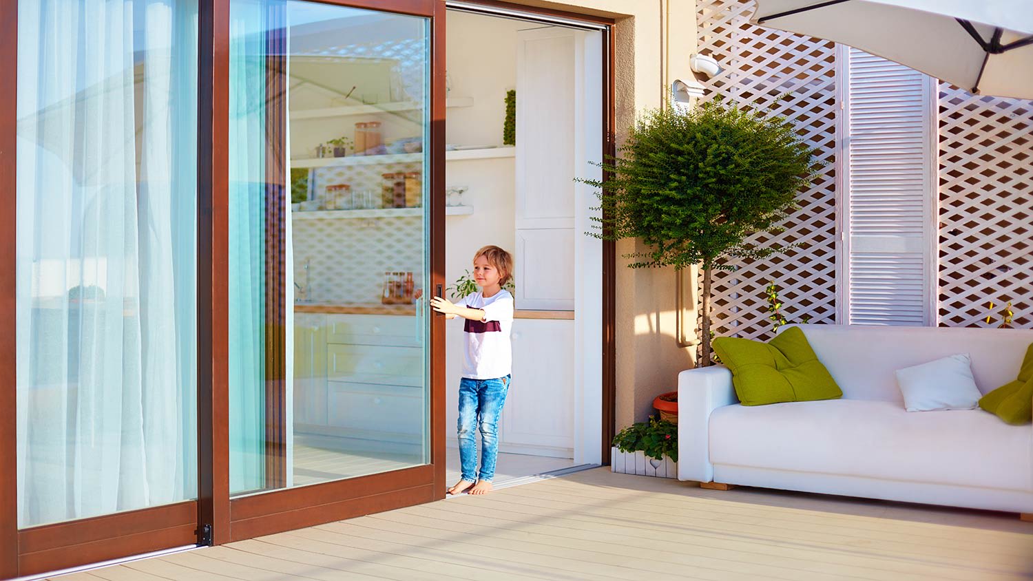 Kid opening sliding door on patio