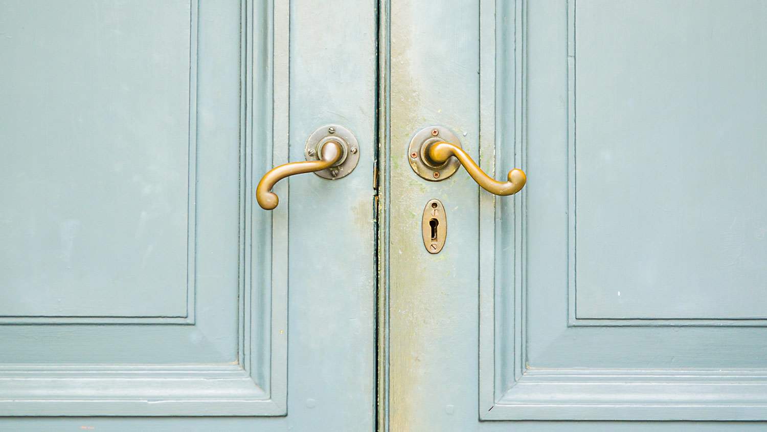 A lever handleset on a wooden blue front door