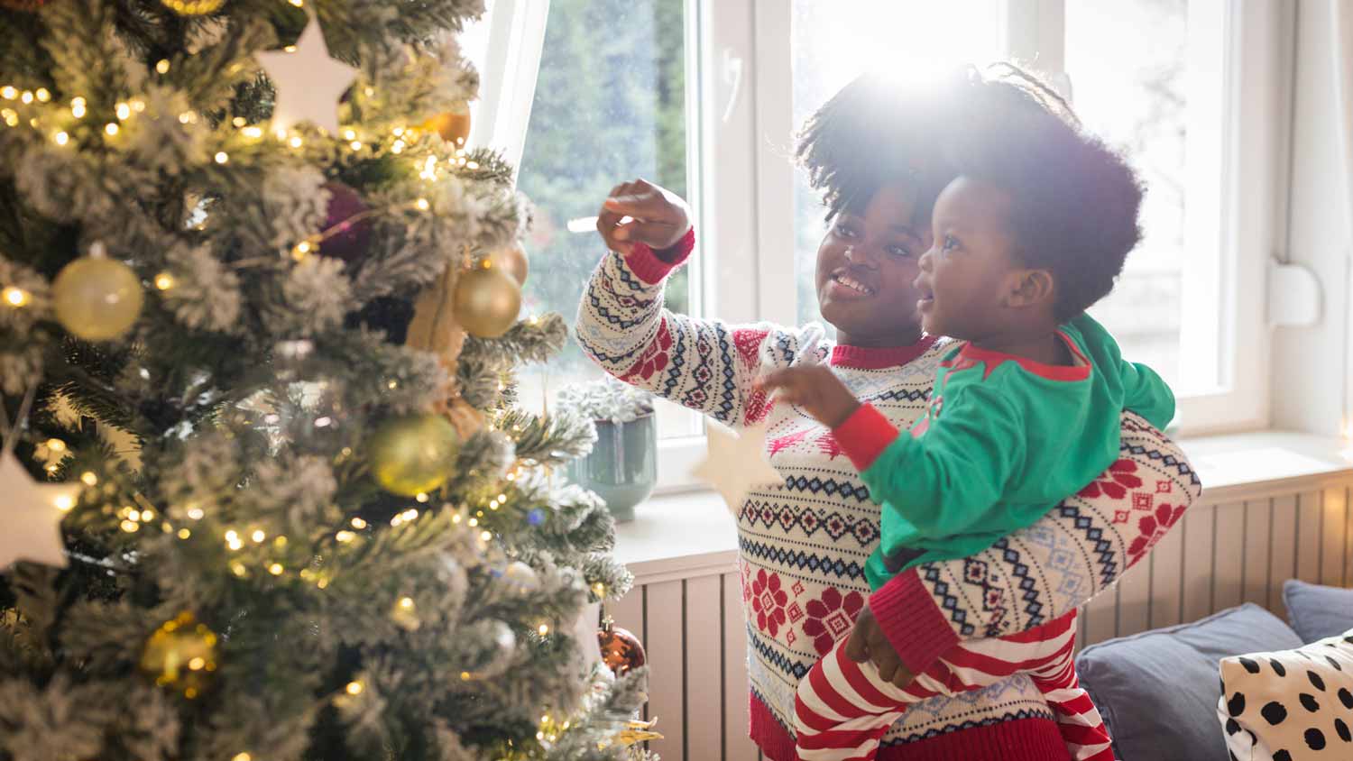 A mother with her son decorating the christmas tree