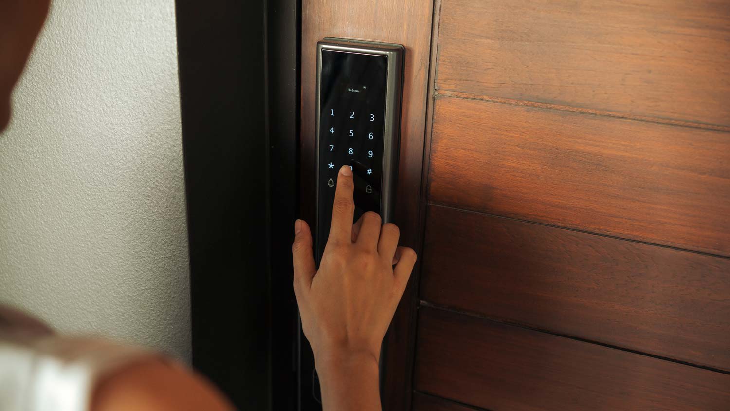 A woman entering a pin to enter the house