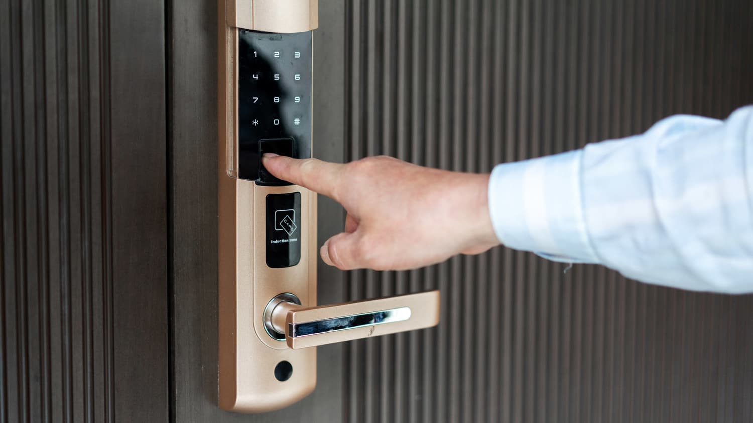 A man’s hand opening a door using a smart lock